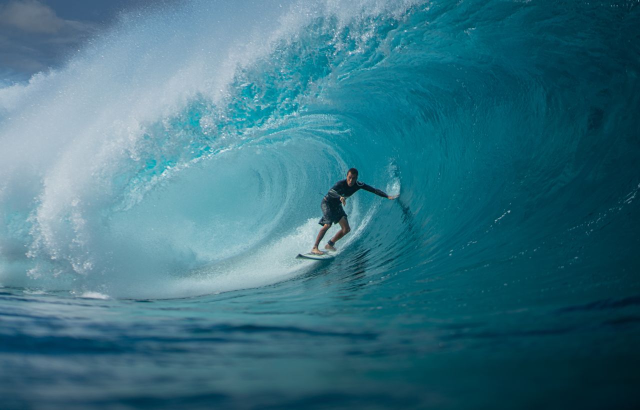 Surfista dentro de uma onda tubular